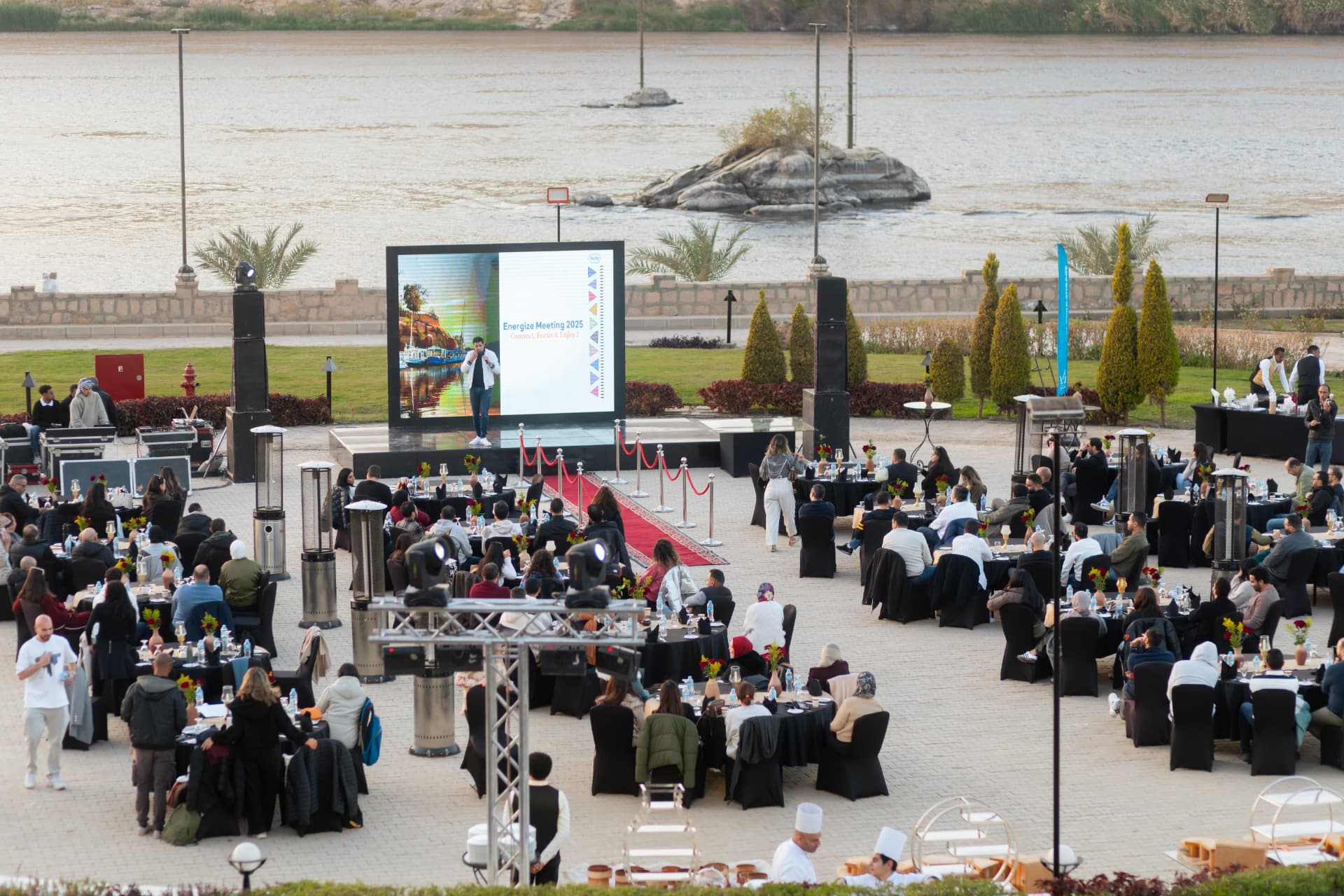 A large corporate gala dinner by the river at sunset