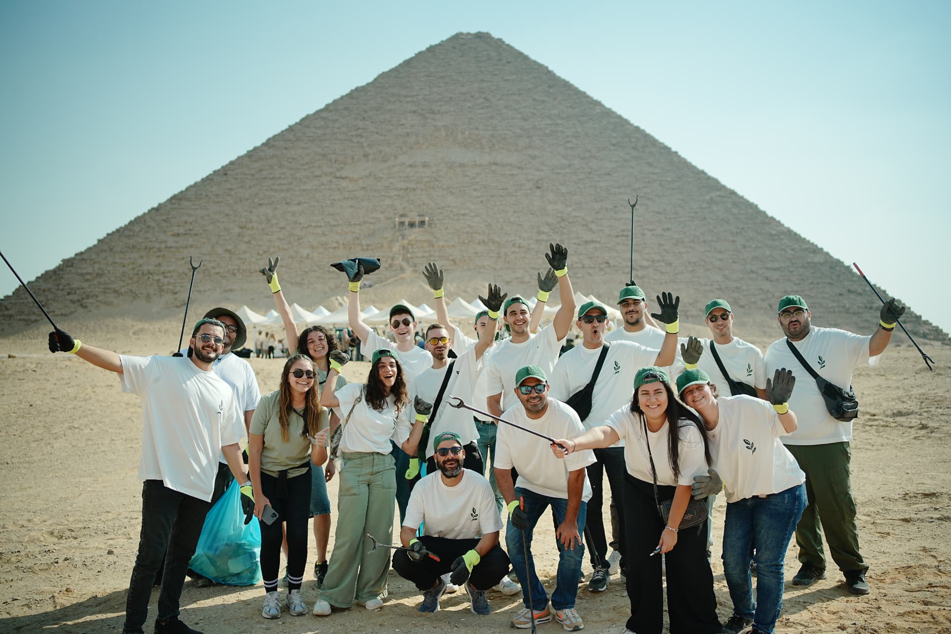 A volunteer team celebrating a CSR cleanup at the Pyramids of Giza