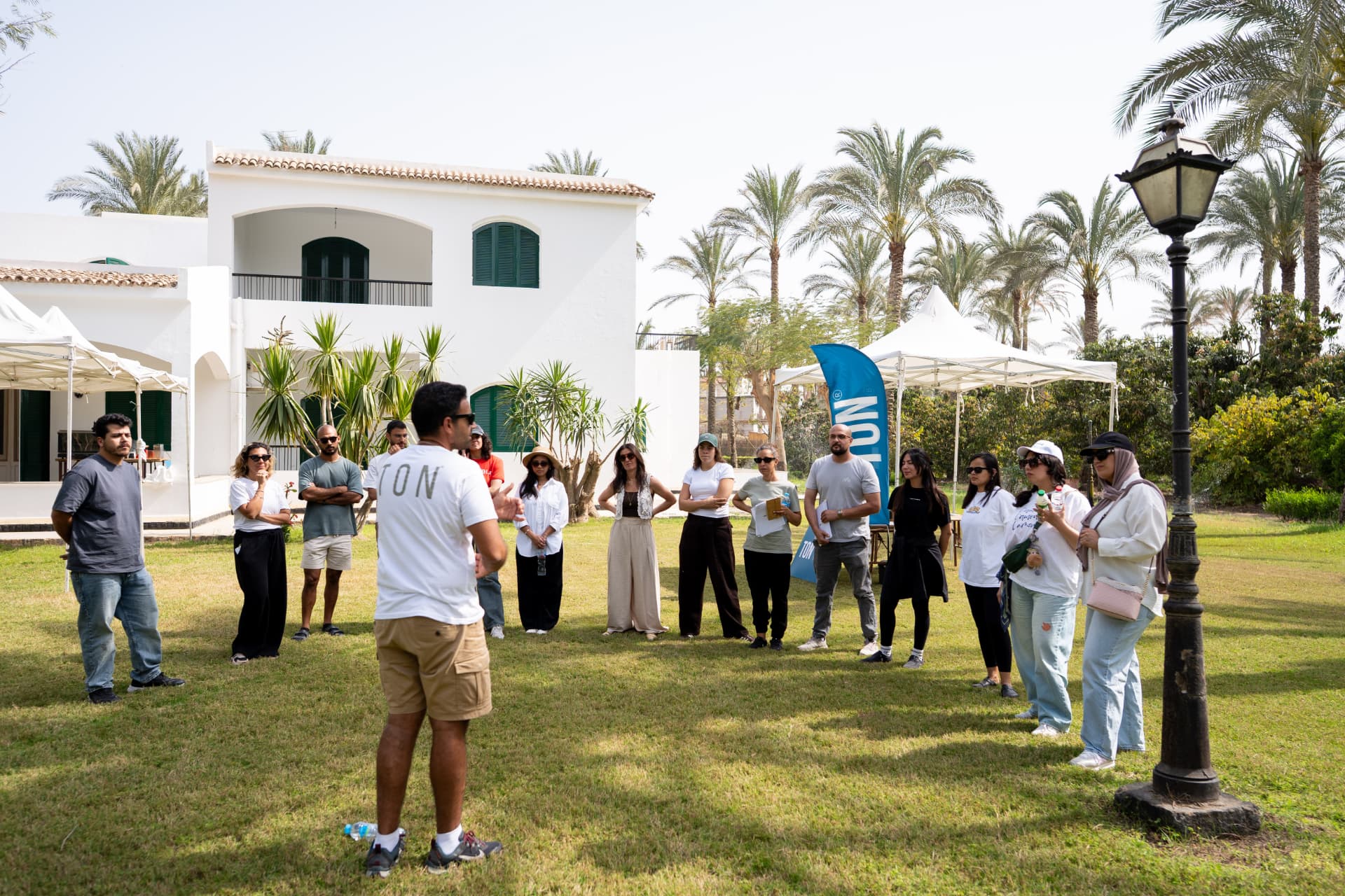 A facilitator briefing a team on a lawn before activities begin