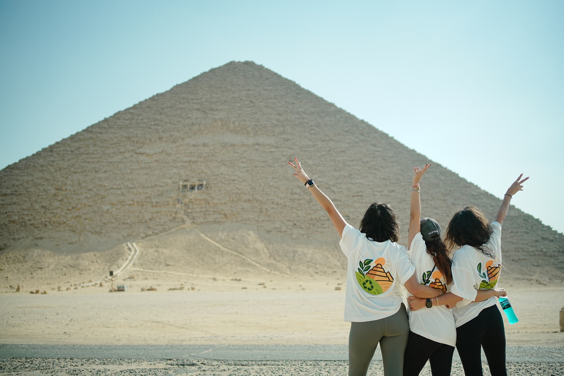 Team members celebrating in front of the Pyramids of Giza