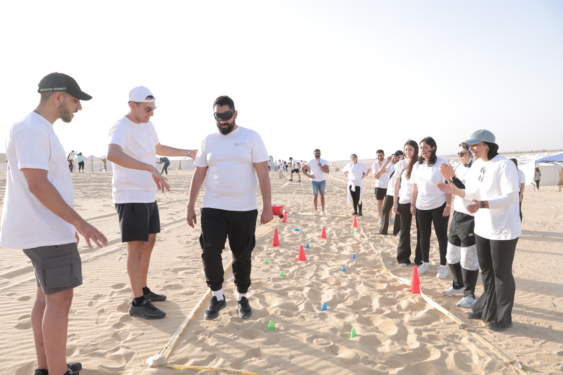 A blindfolded team-building challenge on the sand